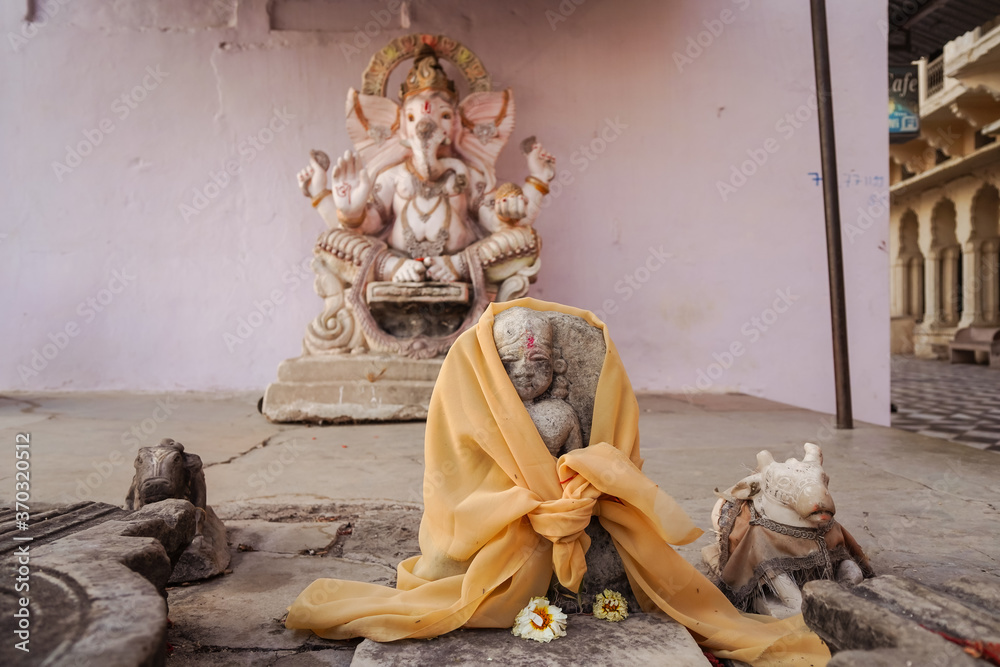 Buddhist religious sculpture with flowers near Pushkar sacred lake