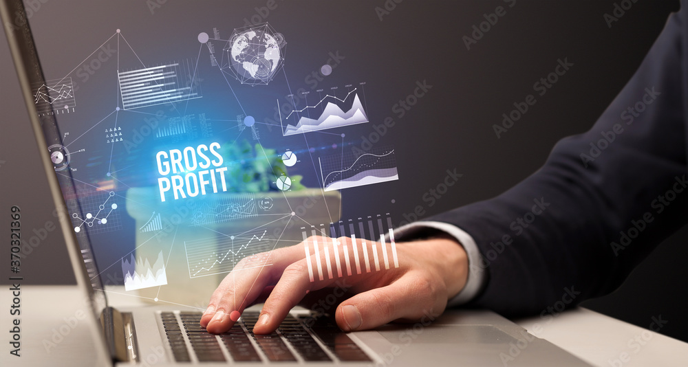 Businessman working on laptop with GROSS PROFIT inscription, new business concept Businessman working on laptop with GROSS PROFIT inscription, new business concept