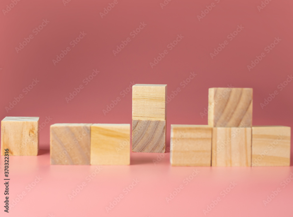 Empty wooden cube on a pink background. For new ideas to be put into the picture.Rear focus.