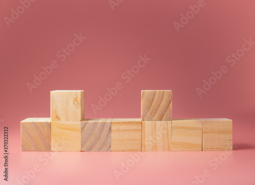Fototapeta Naklejka Na Ścianę i Meble -  A wooden cube on a pink background.For new ideas to be put into the picture.