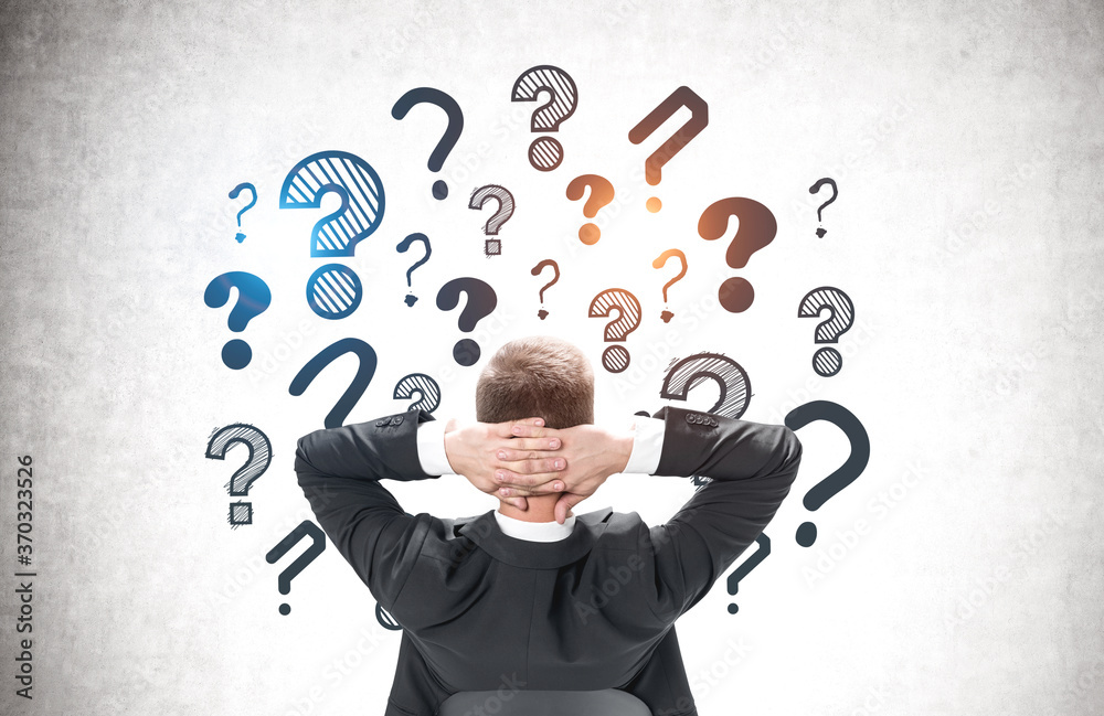 Confident man looking at question marks Confident man looking at question marks