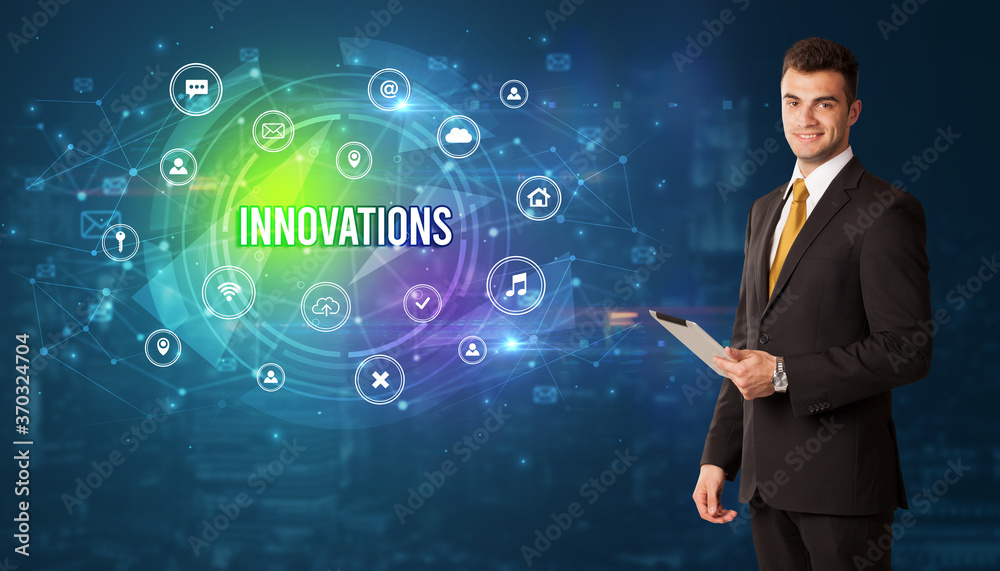 Businessman thinking in front of technology related icons and INNOVATIONS inscription, modern technology concept Businessman thinking in front of technology related icons and INNOVATIONS inscription, modern technology concept