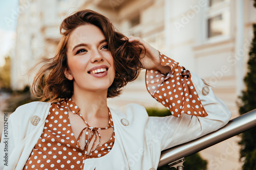 Photo Cheerful brown-haired woman in elegant outfit looking around