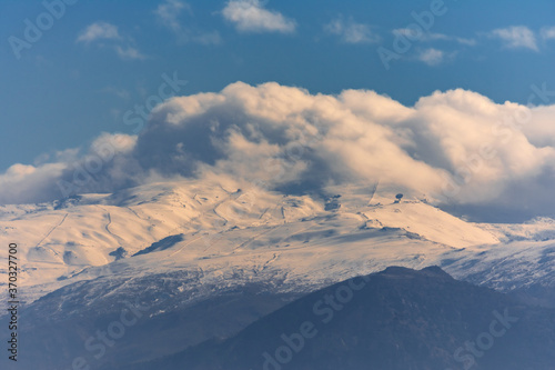 View of Sierra Nevada with snow and clouds hiding the peaks. © M. Perfectti