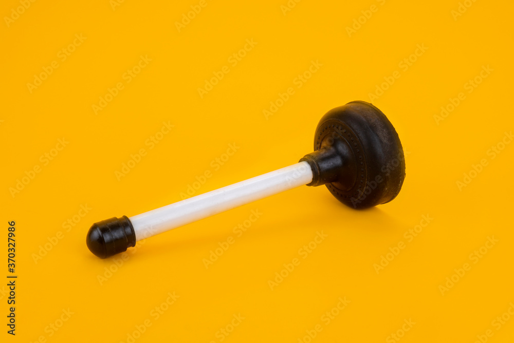 A plunger with a white handle on a yellow background A plunger with a white handle on a yellow background