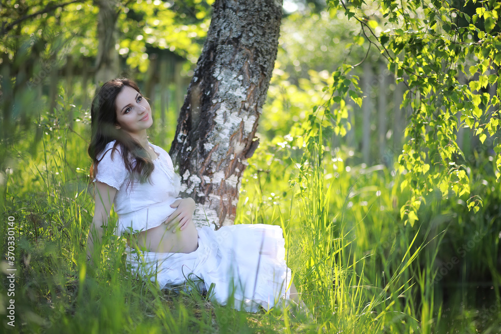 Pregnant woman in nature for a walk summer Pregnant woman in nature for a walk summer