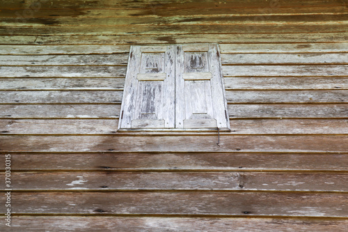 Old wooden window on grunge wooden wall planks abstract textured background. Concept for construction,interior,retro style and furniture. Horizontal.