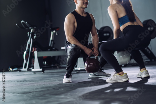 Sporty team with kettlebells and exercise workout at fitness gym.