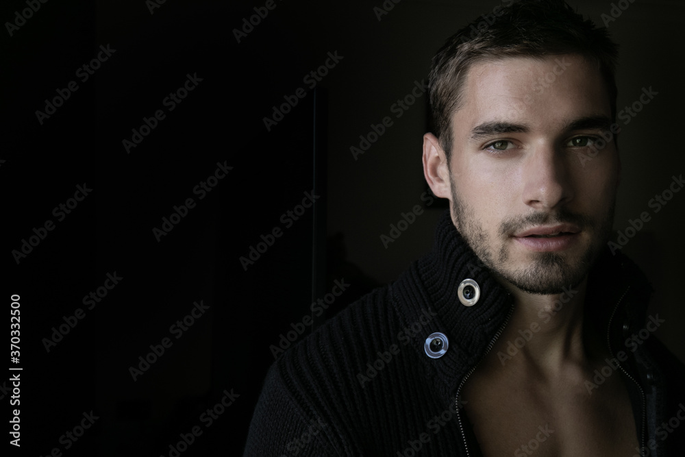 Portrait of good looking man with beard and open cardigan looking at camera Portrait of good looking man with beard and open cardigan looking at camera