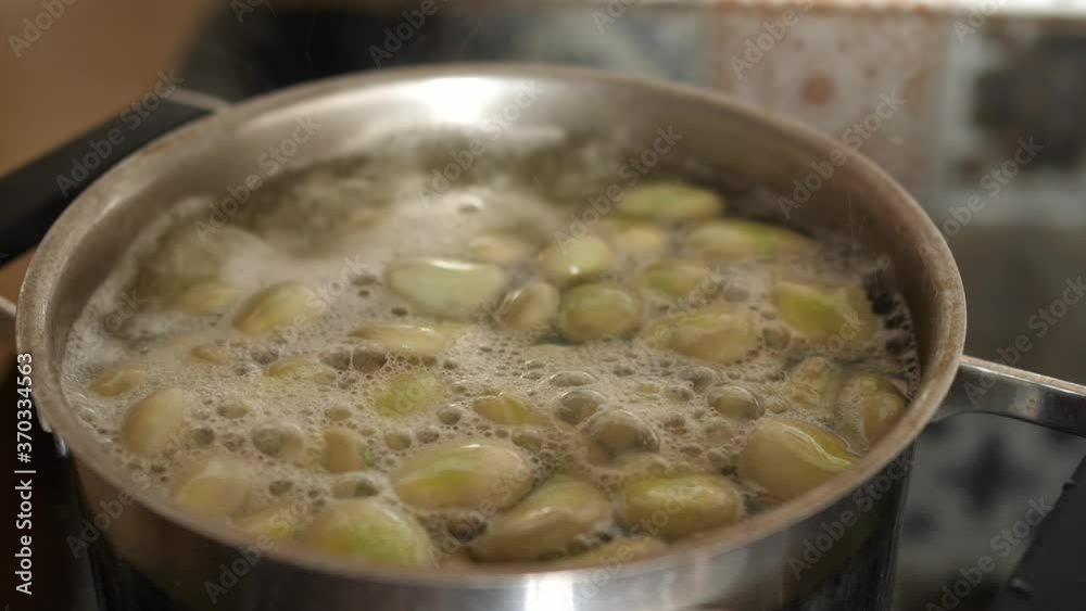 broad beans are boiling in a pot broad beans are boiling in a pot