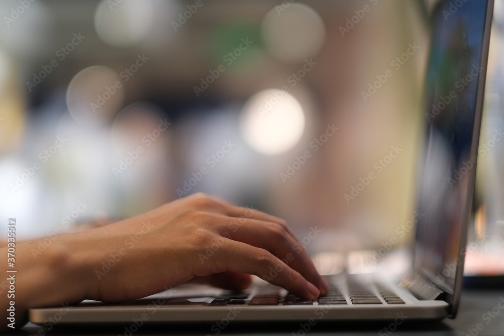 close up hands typing on keyboard of laptop computer. Colorful bokeh background close up hands typing on keyboard of laptop computer. Colorful bokeh background
