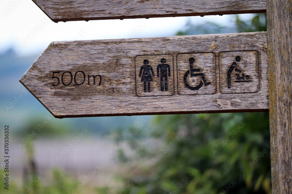 Wooden signpost for the toilets