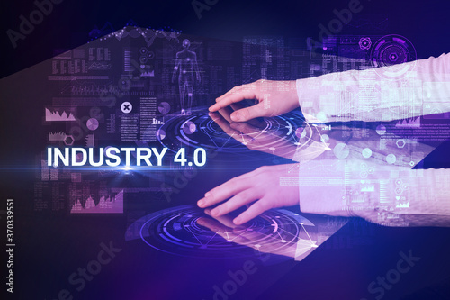 Businessman touching huge display with INDUSTRY 4.0 inscription, modern technology concept