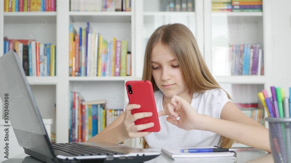 Kid Using Smartphone Studying in Video Conferencing, Child Learning, Writing in Library, Schoolgirl Chatting, Online Education Kid Using Smartphone Studying in Video Conferencing, Child Learning, Writing in Library, Schoolgirl Chatting, Online Education