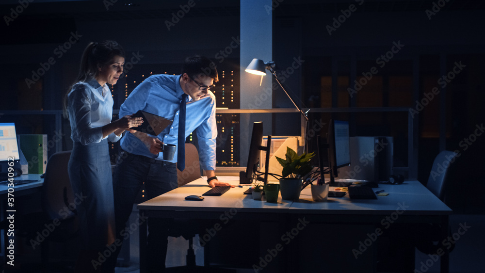 Portrait of Businessman and Female Project Manager Talking and Discussing Project, Account Handling and Strategic Moves. Professional People Late at Night in Big Corporate Office