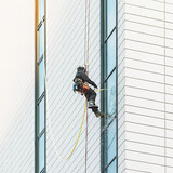 Worker washes the windows of the modern skyscraper.