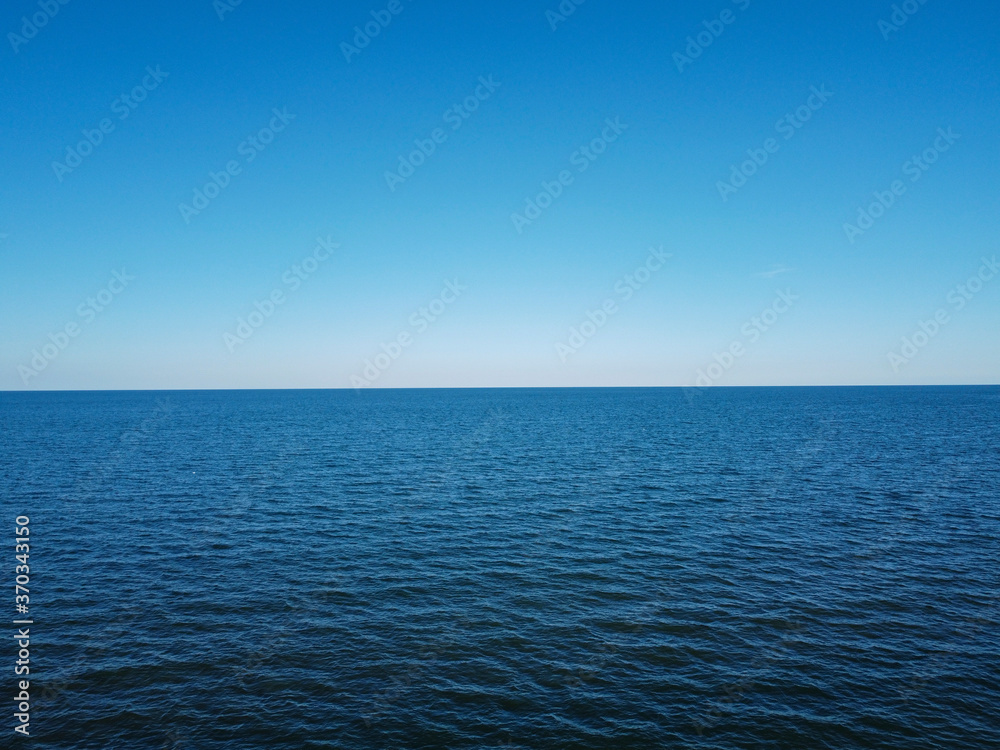 Merger of sky and sea in the horizon, blue water and cloudless sky.