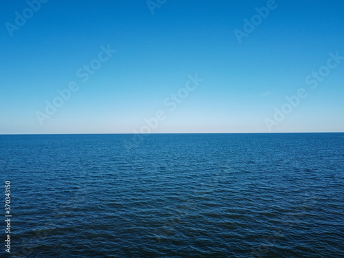 Merger of sky and sea in the horizon, blue water and cloudless sky.