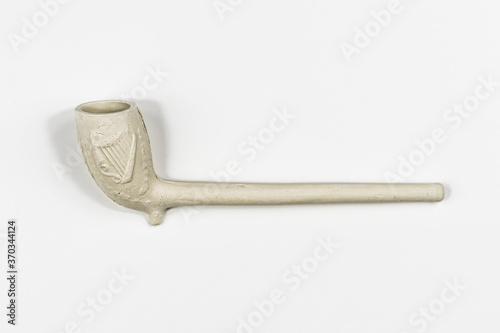 Traditional classic style white clay smokers pipe shot sideways on in a white studio.