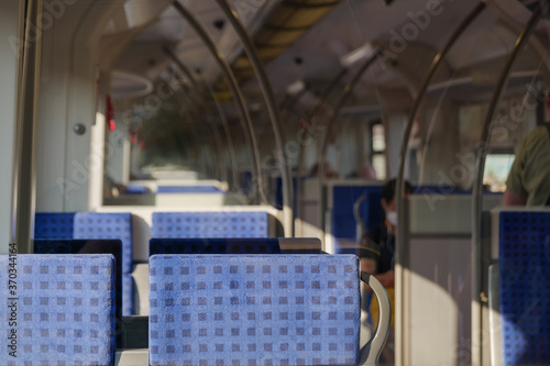 Interior view of a corridor inside passenger trains with blue fabric seats of German railway train system. Empty vacant passenger car inside the train.