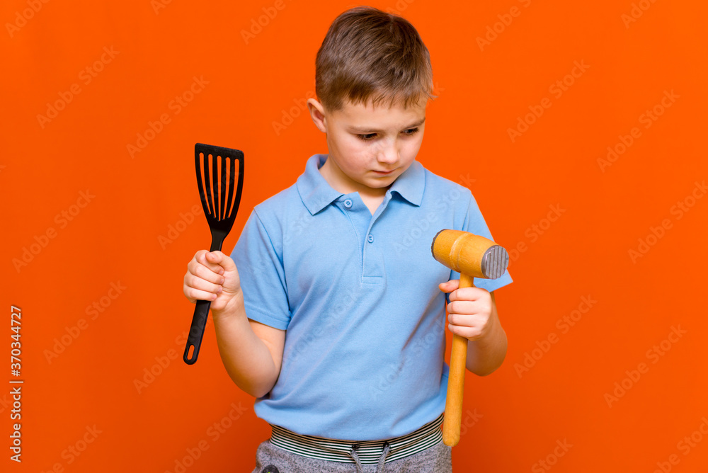 professional youn boy kid chef on orange background.housewifes Green concept. professional youn boy kid chef on orange background.housewifes Green concept.