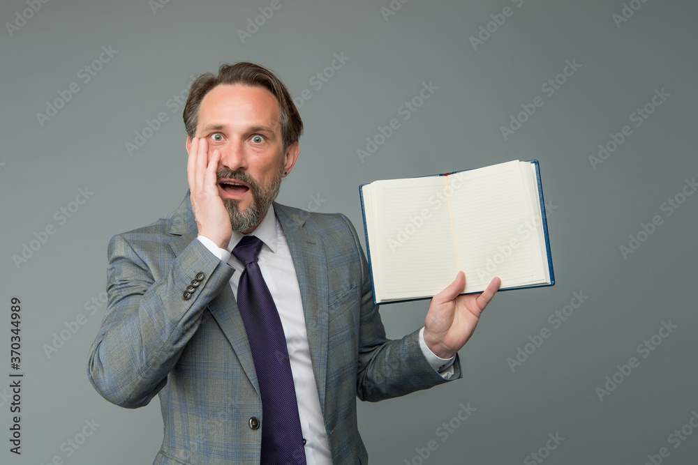 businessman surprised by interesting information in book. get ready for business training. successful man in business suit hold notebook. planning and success concept. feel the surprise