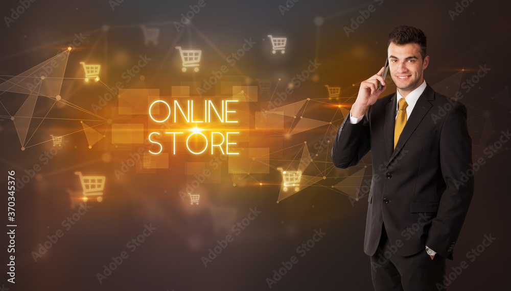 Businessman with shopping cart icons and ONLINE STORE inscription, online shopping concept Businessman with shopping cart icons and ONLINE STORE inscription, online shopping concept