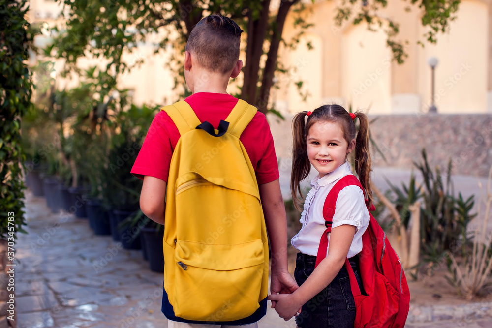 Back to school. Pupils with backpacks going to school Back to school. Pupils with backpacks going to school