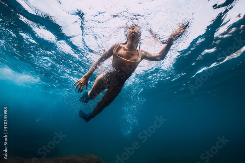 Sporty woman with fins swim in sea. Swimming in ocean