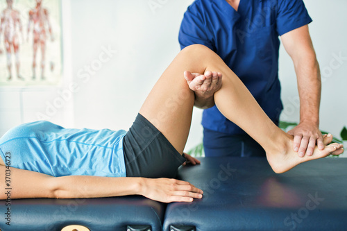 Male Physical Therapist Stretching a Female Patient photo
