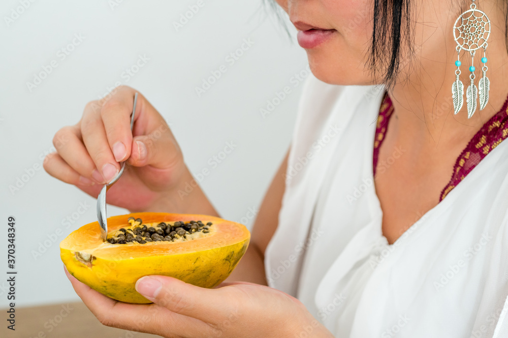 Femme mangeant une papaye