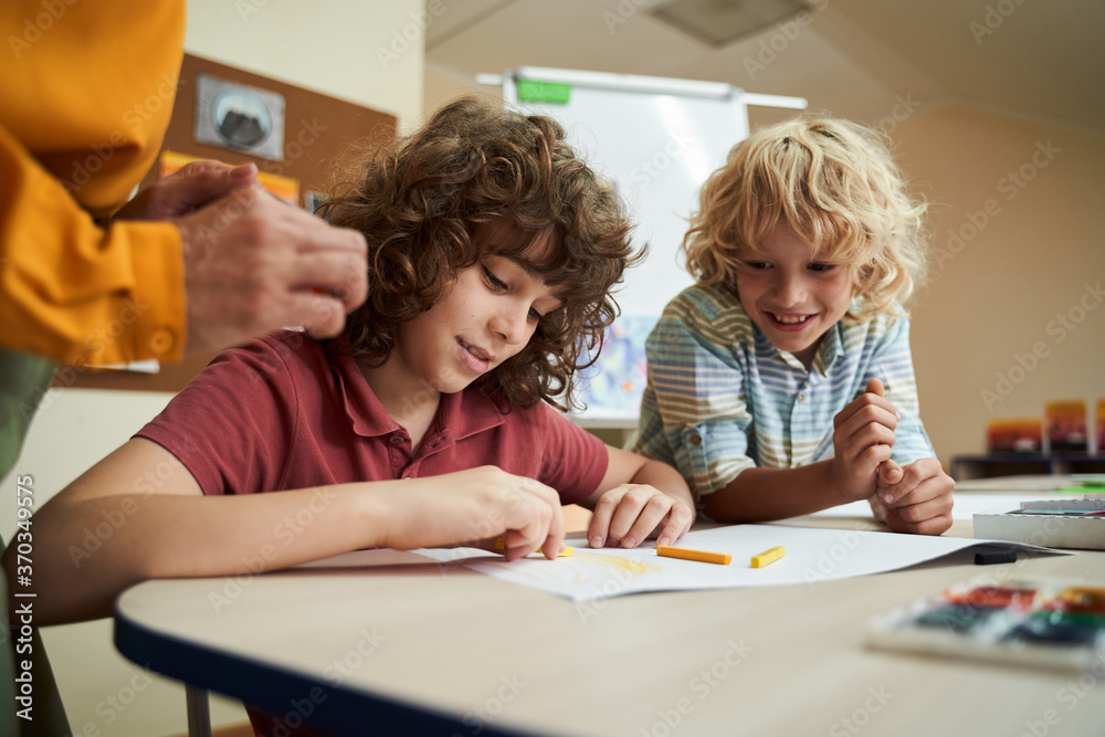 Cute boys drawing with colour pencils at school Cute boys drawing with colour pencils at school