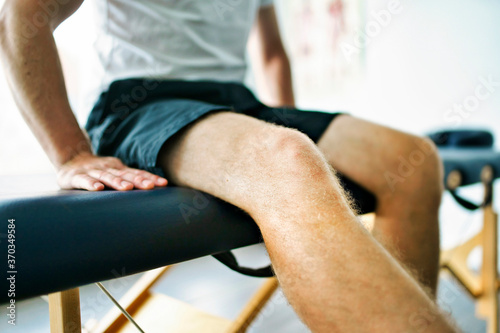 A Modern rehabilitation physiotherapy place with man client sit on table