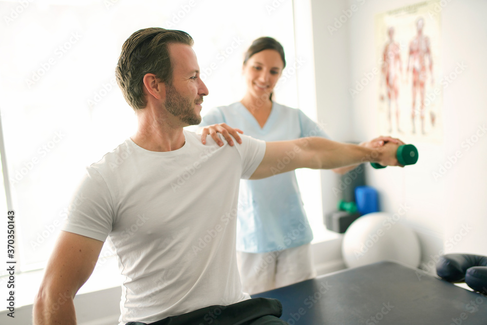 Fototapeta premium physiotherapist doing treatment with patient in bright office