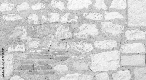 White texture of an old wall made of exposed stones - old vintage texture design - large image in high resolution 
