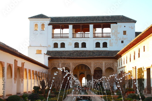 View of The Generalife courtyard, with its famous fountain and garden through an arch. Alhambra de Granada complex at Granada Andalusia, Spain, Europe.