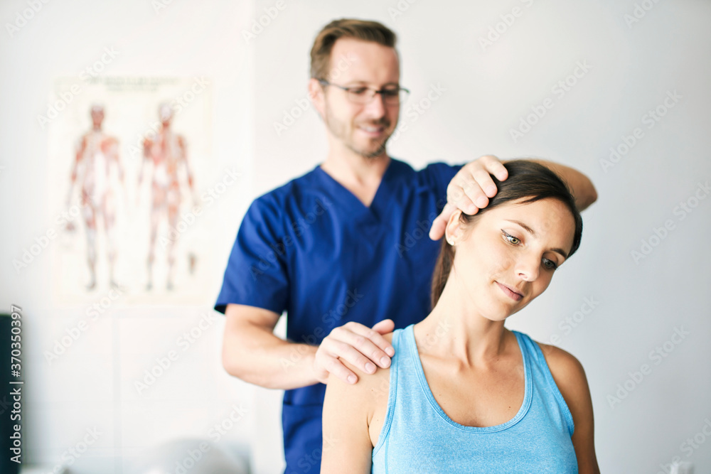 Fototapeta premium Male Physical Therapist Stretching a Female Patient nack