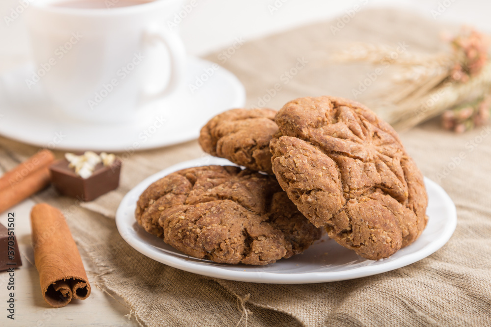 homemade oatmeal cookies with a cup of cocoa on a white wooden background. side view, selective focus. homemade oatmeal cookies with a cup of cocoa on a white wooden background. side view, selective focus.