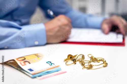 Businessman in the back, euro banknotes and gold jewellry in the front photo