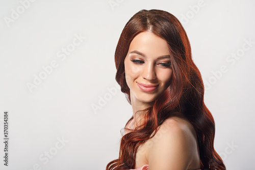 red-haired beautiful young woman on a light background