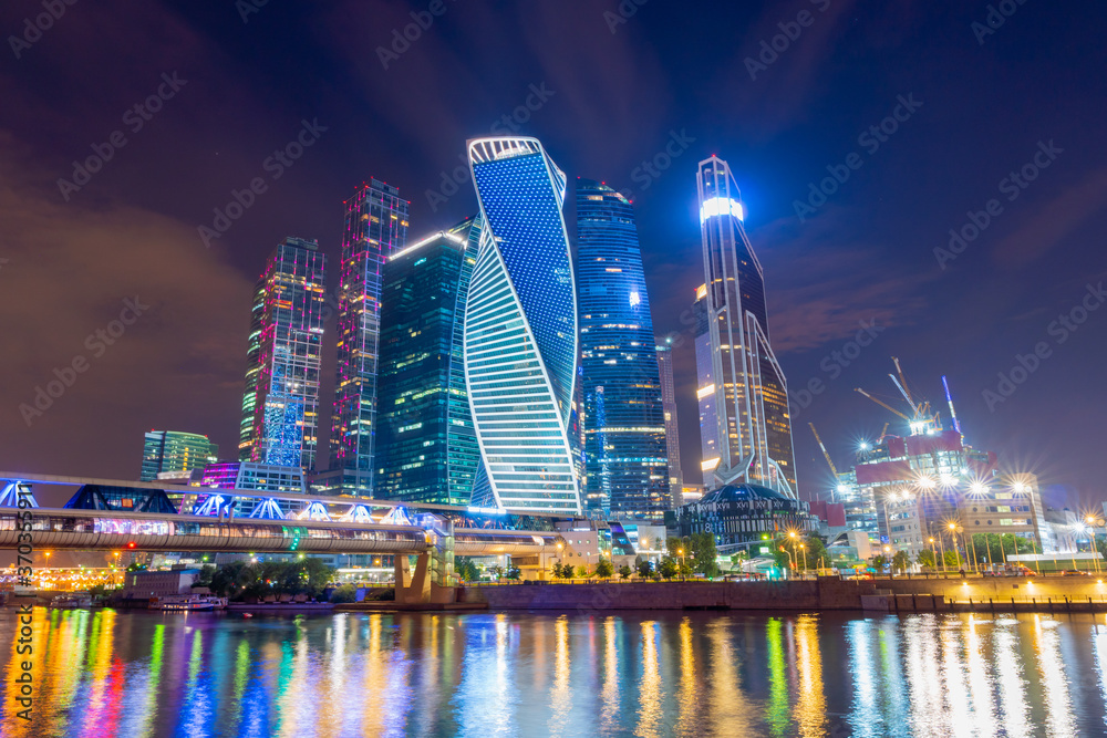 Moscow skyline panorama at night with colorful lights reflections on the surface of the river Moskva. Modern type of buildings for business, social life, and accommodation. Amazing at blue hour time. 