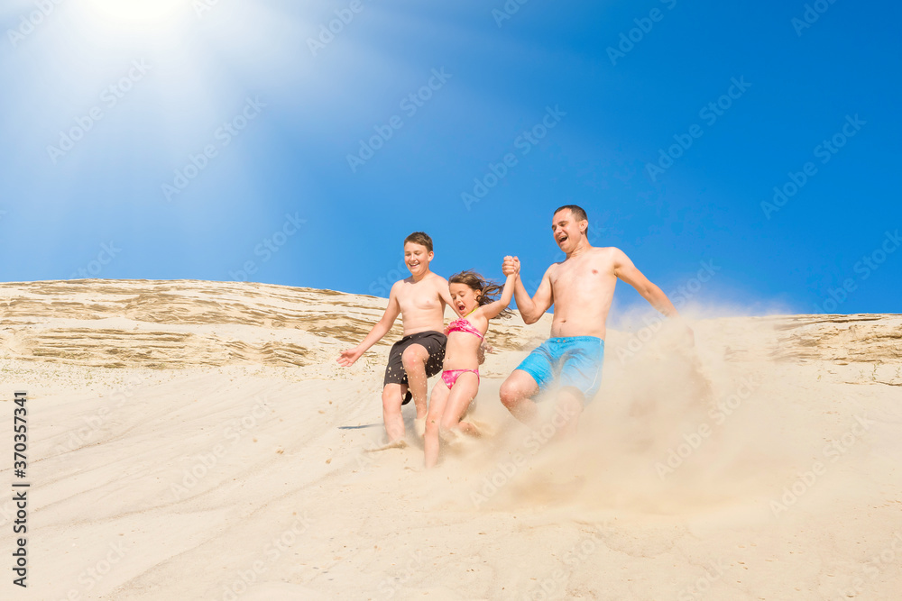 Happy family have fun running along the sand on the beach on a sunny summer day. Family vacation. Healthy lifestyle. Happy family have fun running along the sand on the beach on a sunny summer day. Family vacation. Healthy lifestyle.