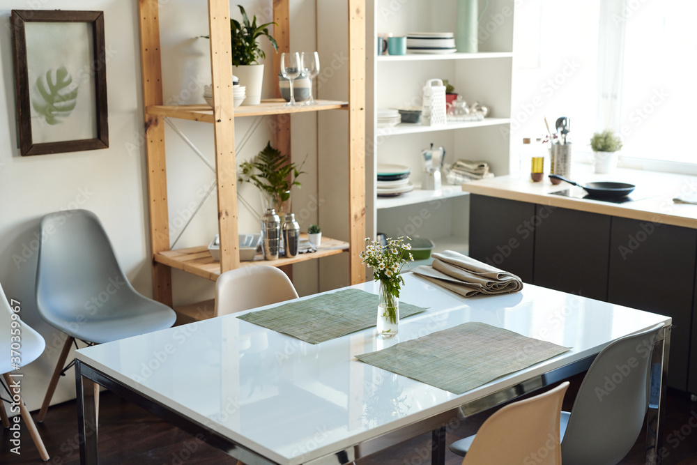 White rectangular table with bunch of wildflowers in vase between grey napkins White rectangular table with bunch of wildflowers in vase between grey napkins