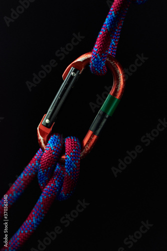 Rope and carabiner on black background selective focus