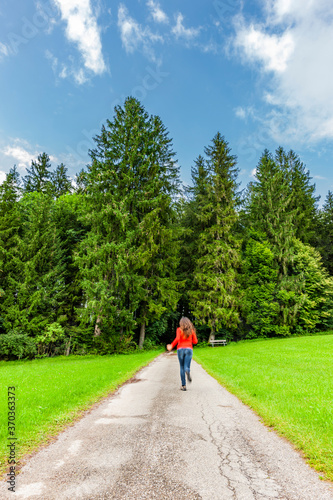 Frau mit Rotem Pullover läuft auf einem Waldweg