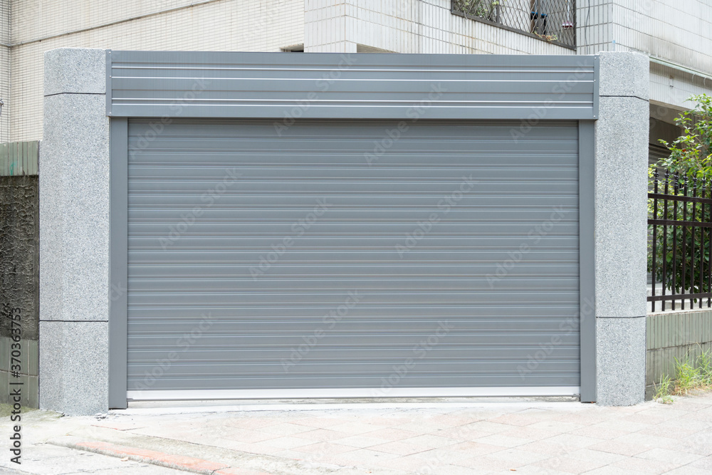 A closeup shot of automatic metal roller door used in factory, storage, garage, and industrial warehouse. The corrugated and foldable metal sheet offer space saving and provide urban and rustic feel A closeup shot of automatic metal roller door used in factory, storage, garage, and industrial warehouse. The corrugated and foldable metal sheet offer space saving and provide urban and rustic feel