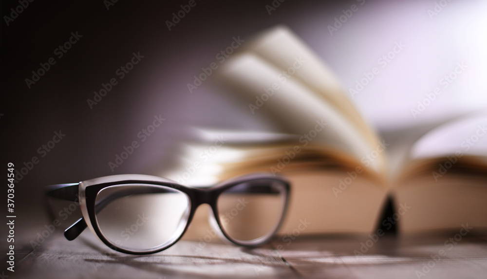 Composition with glasses and open book on the table Composition with glasses and open book on the table