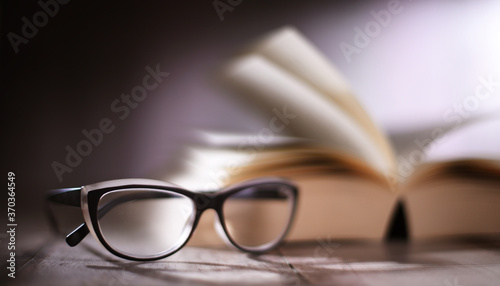 Composition with glasses and open book on the table