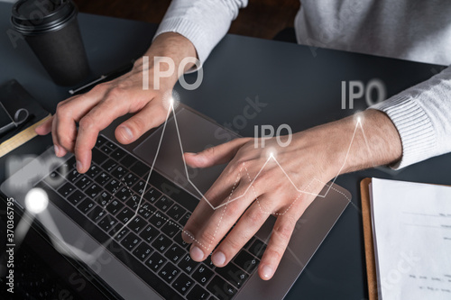 Man using computer. Hands typing laptop. Double exposure with IPO hologram. Close up. Initial primary offering investment concept.