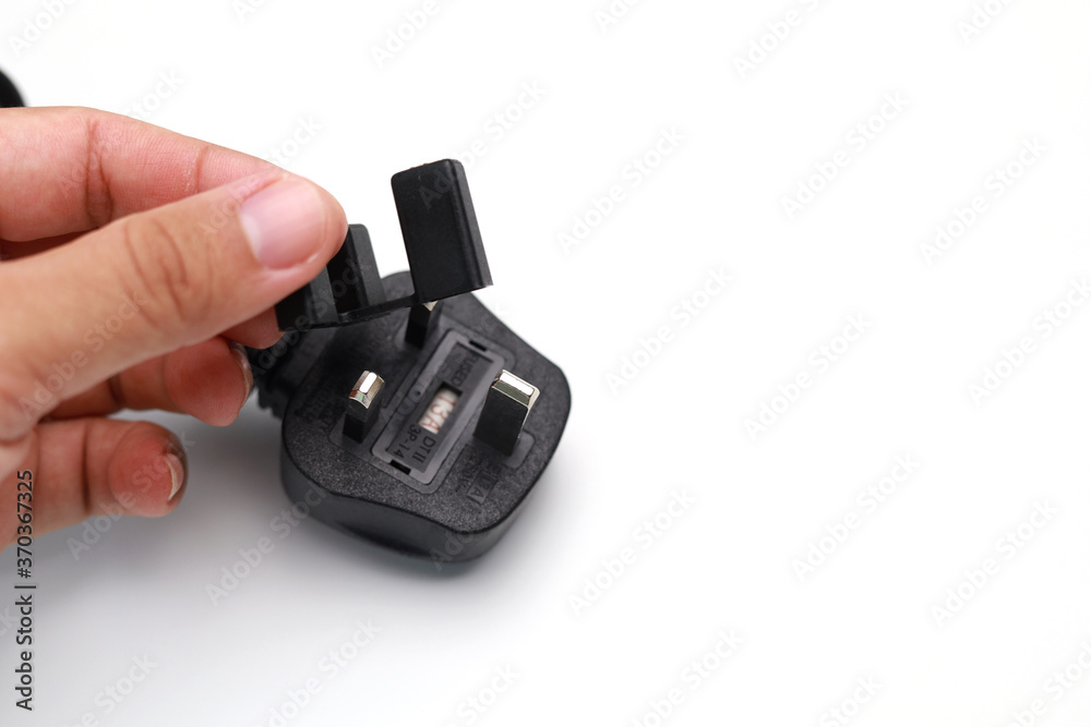 Hand holding a protective metal case for 3 pins electric plug isolated on the white background Hand holding a protective metal case for 3 pins electric plug isolated on the white background